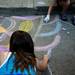 Anna Szalkowski, 12, and Sophie Motawi, 9, use chalk at the Huron River Water Trail tent to decorate sewage drains during the Mayor's Green Fair on Friday, June 16. Daniel Brenner I AnnArbor.com